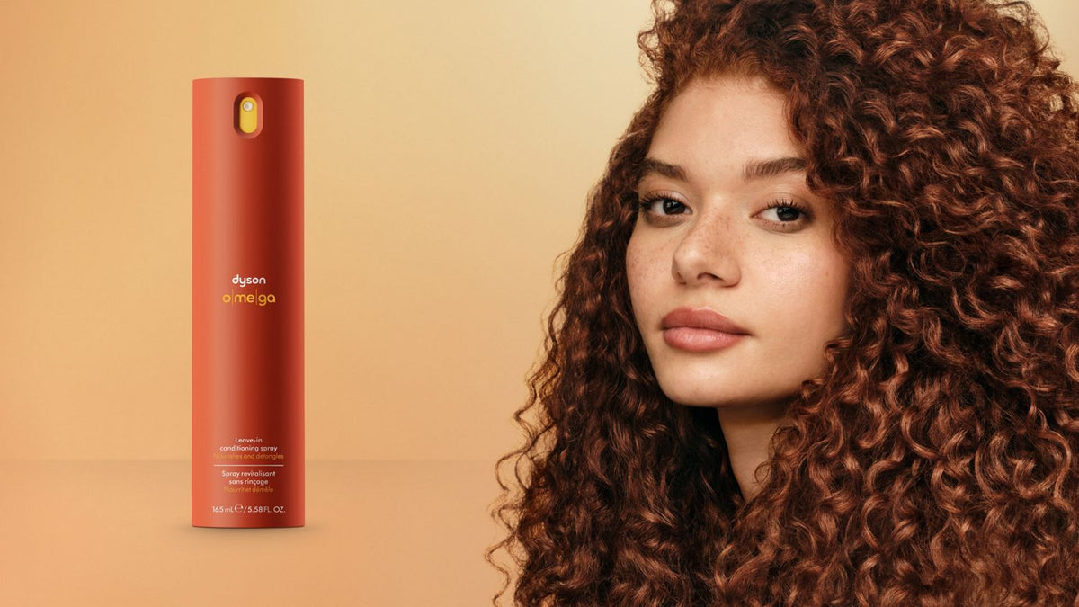 Dyson Omega™ leave-in conditioning spray next to a model with nourished hair.