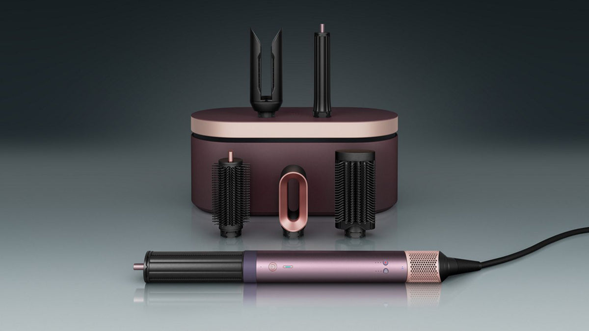 The Dyson Airwrap Co-anda2x multi-styler and dryer with the Airsmooth attachment next to a blonde model.