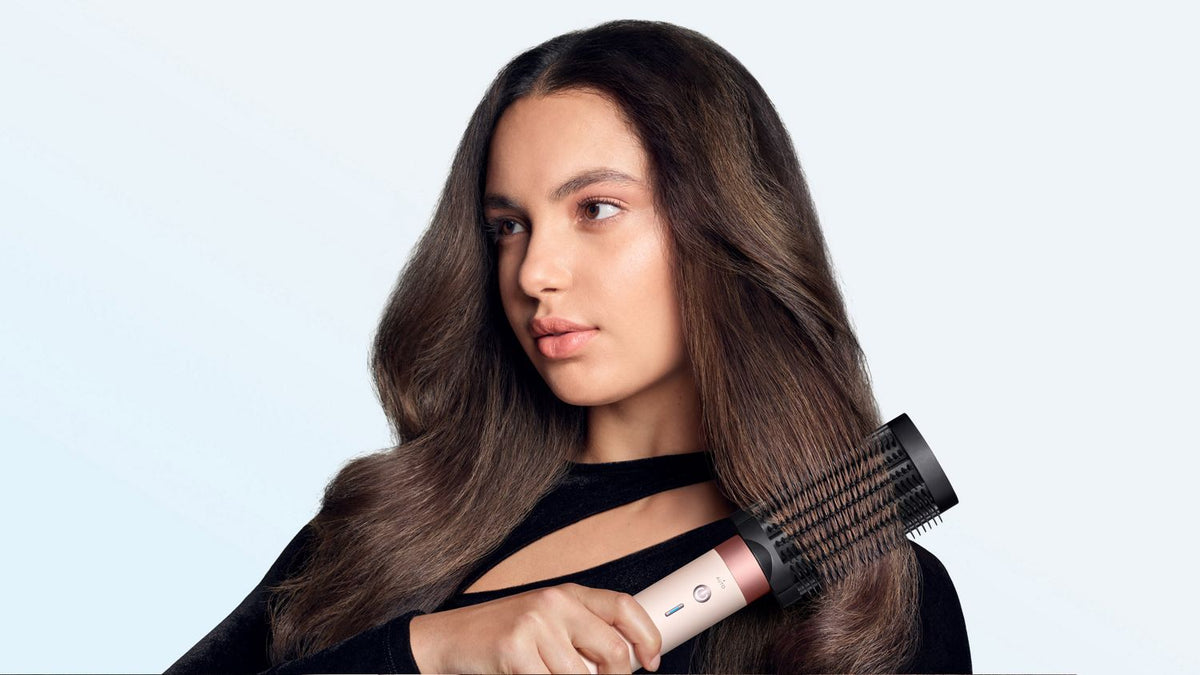 Model brushes her hair with the Dyson Anti-snag loop brush 2x.