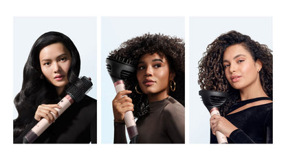 A trio of models dry and style their hair with the Dyson Airwrap Co-anda2x multi-styler and dryer.