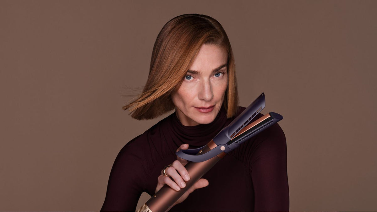 Model holds the Dyson Airwrap Co-anda2x multi-styler and dryer.