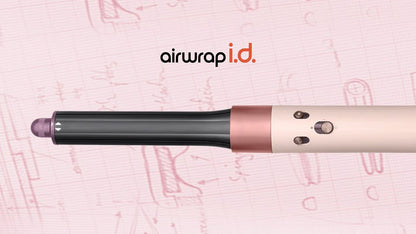 The Dyson Airwrap ID in front of pink engineering sketches.